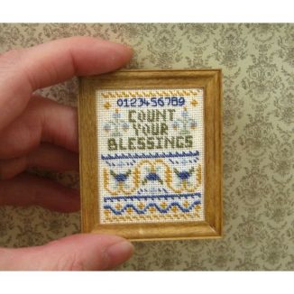 Dollhouse needlepoint sampler Count your blessings being held for scale